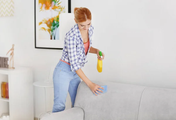 Donna pulizia divano a casa — Foto Stock