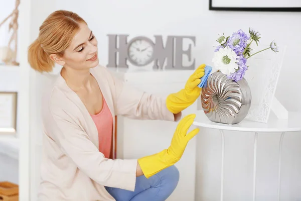Frau wischt Vase zu Hause ab — Stockfoto