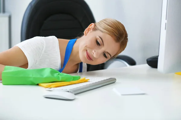 Жінка витирає клавіатуру в офісі — стокове фото