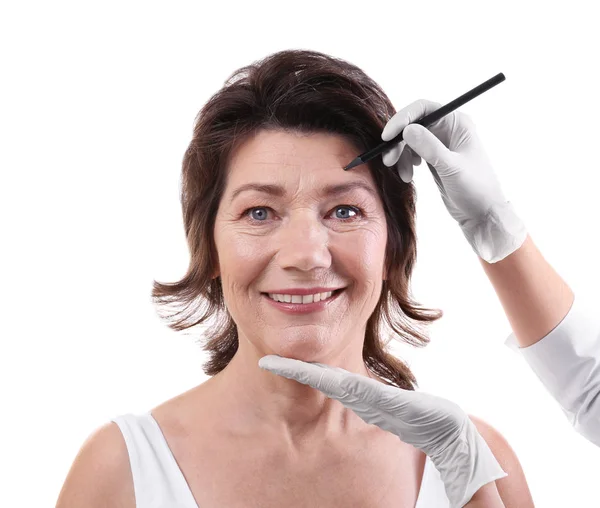 Surgeon drawing marks on female face — Stock Photo, Image