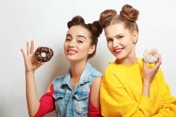 Женщины с вкусными пончиками — стоковое фото