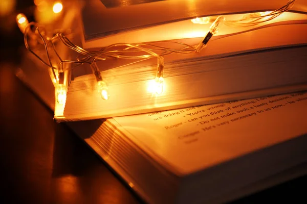 Книги і красива гірлянда на столі — стокове фото