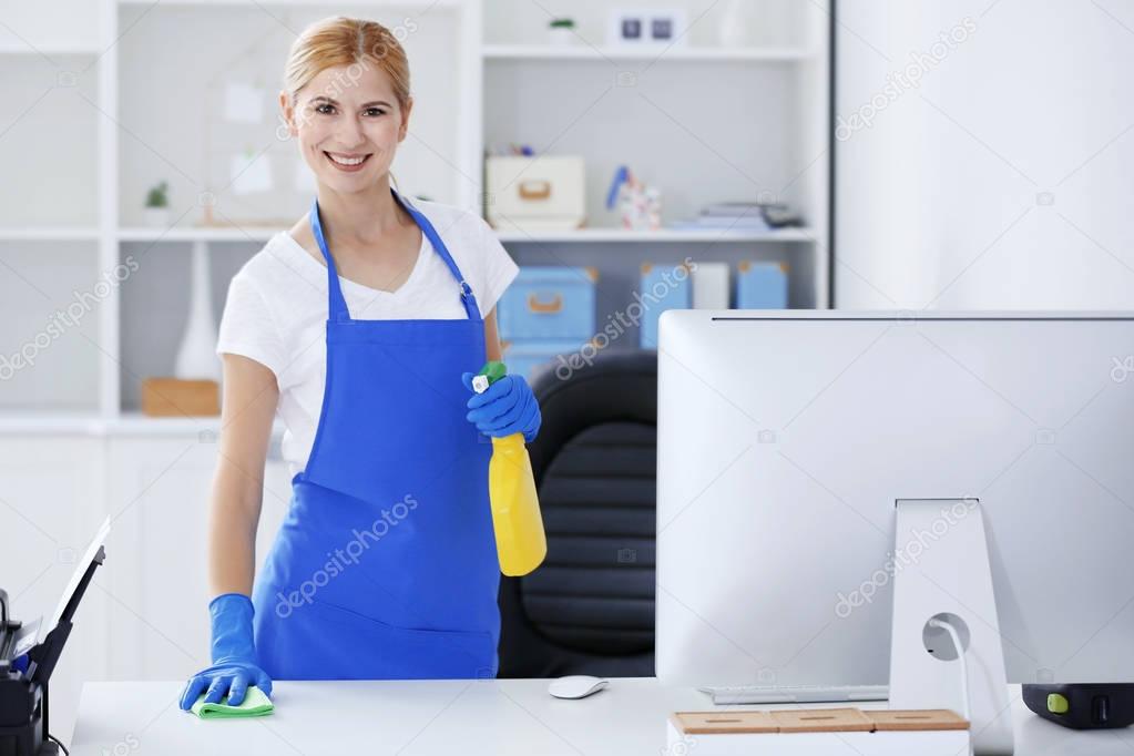woman wiping table in office