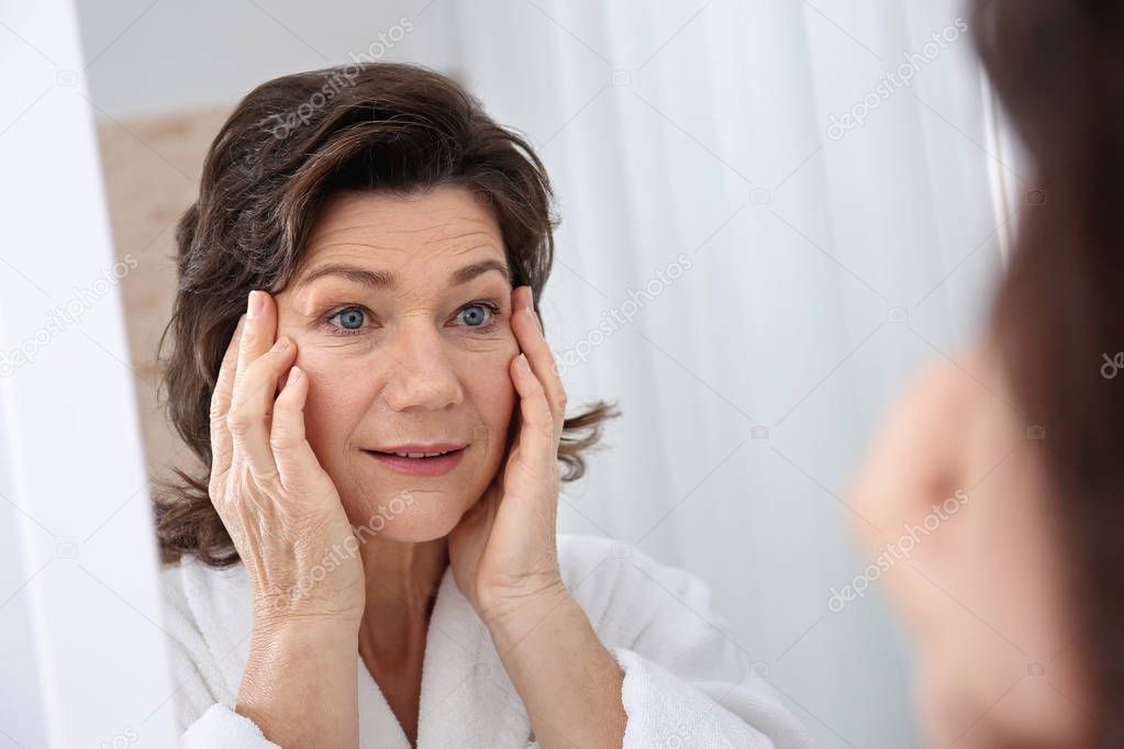 Senior woman touching face