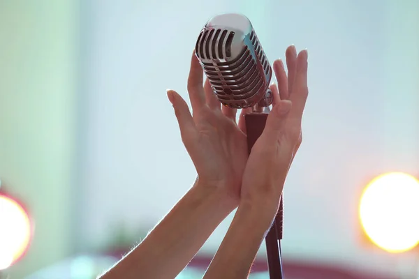 Kobiece ręce trzymając mikrofon retro — Zdjęcie stockowe