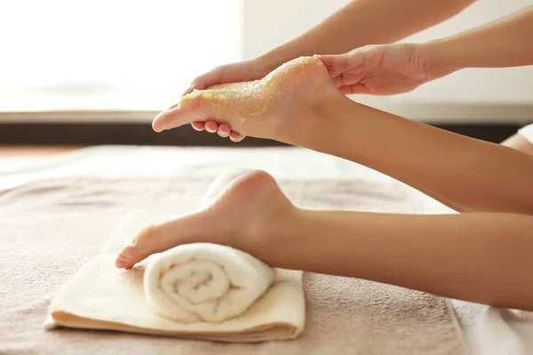 Mani massaggiare piedi femminili con scrub — Foto Stock