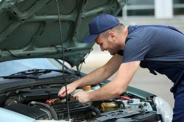 Mechanic in front of the open hood — Stock Photo, Image