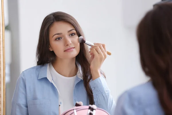 Chica aplicando cosméticos —  Fotos de Stock