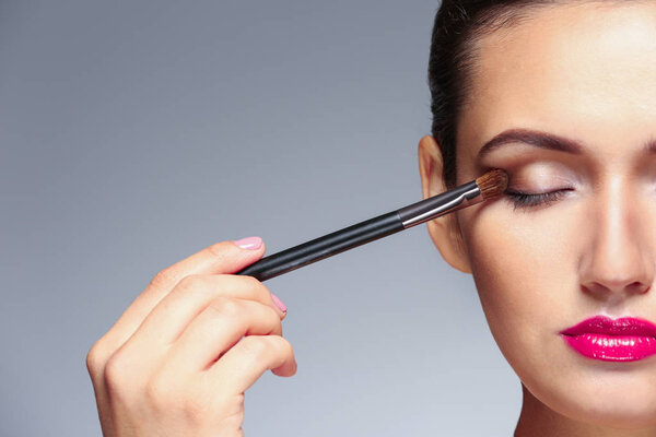 Девушка применяет косметику
