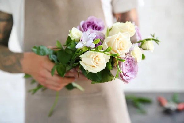 Male florist holding bouquet