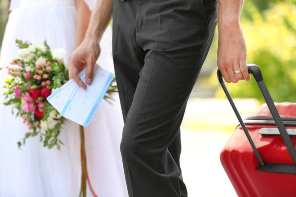 Bride and groom with big suitcase \ — Foto Stock