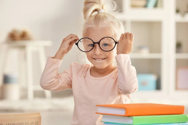 Klein meisje met boeken thuis — Stockfoto