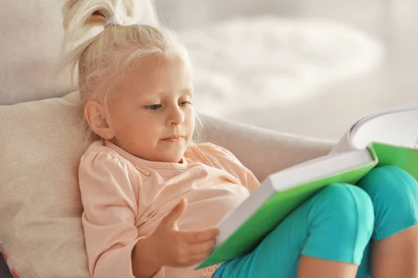 Klein meisje lezen boek op Bank — Stockfoto