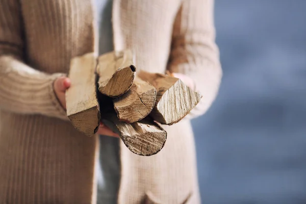 Woman holding pile of firewood — Stock Photo, Image