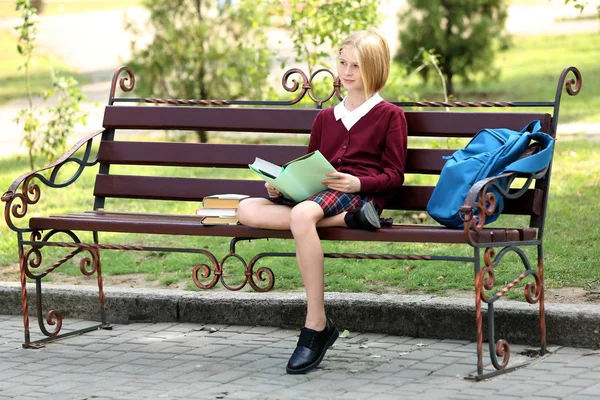 Schoolgirl reading book in park — Stock Photo, Image