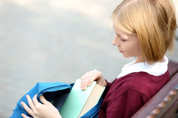Школярка виймає книжку з сумки — стокове фото