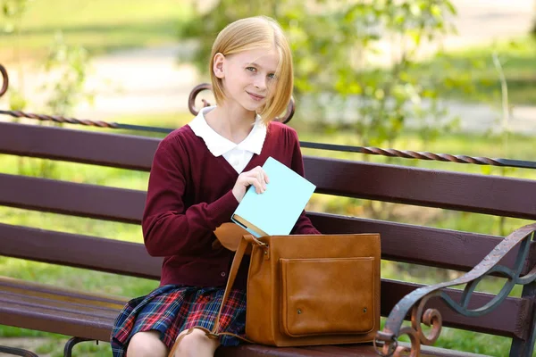 Studentessa con borsa seduta su panchina — Foto Stock