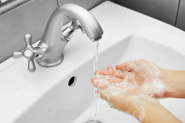 Young woman washing hands in sink — Stock Photo, Image