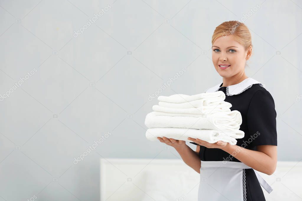 Chambermaid holding pile of towels 