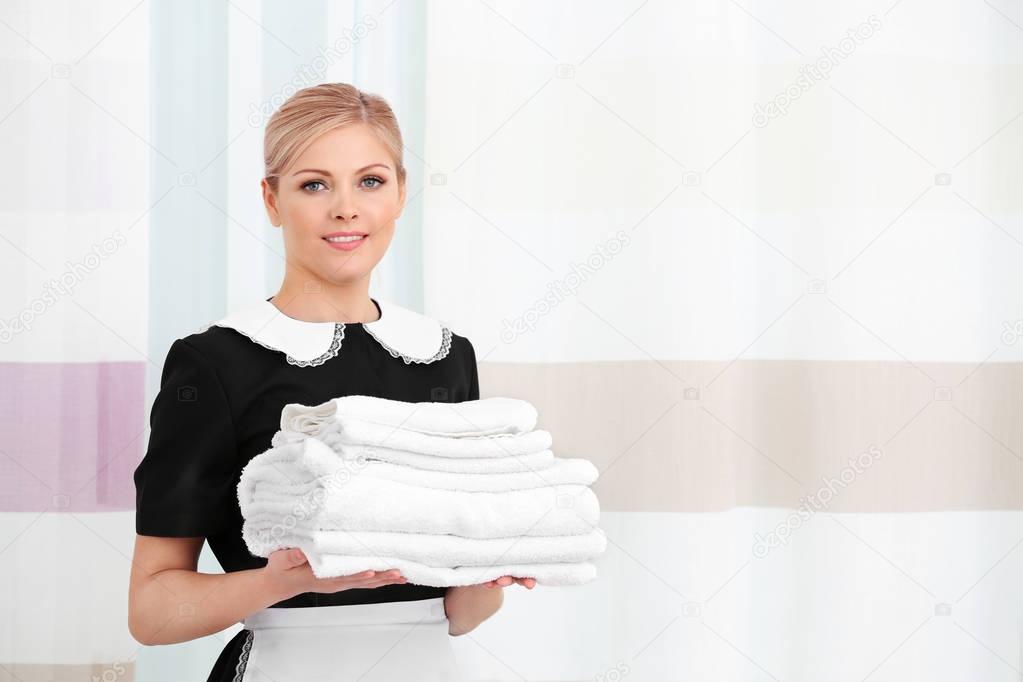 Chambermaid holding pile of towels 