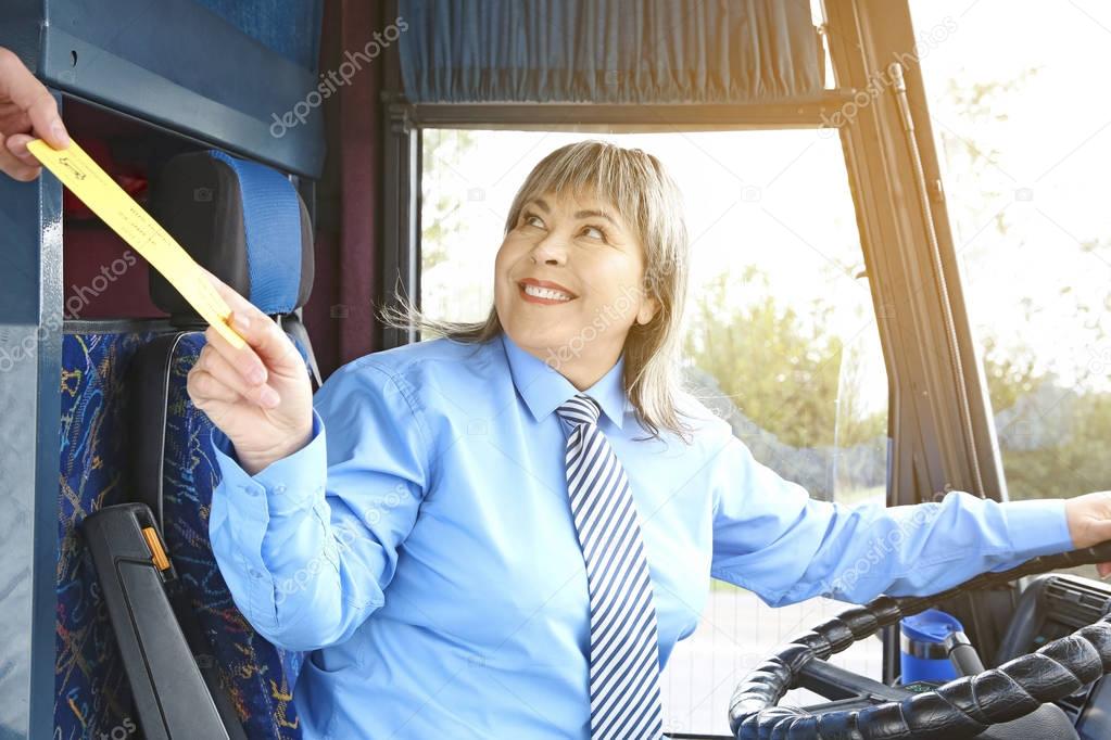 Bus driver taking ticket from passenger