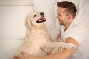 Labrador retriever ile yatan adam