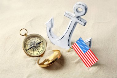 Çapa, pusula ve ABD bayrağı kum. Kolomb Günü kavramı