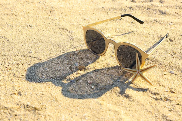 Occhiali da sole e stelle marine sulla spiaggia di sabbia — Foto Stock