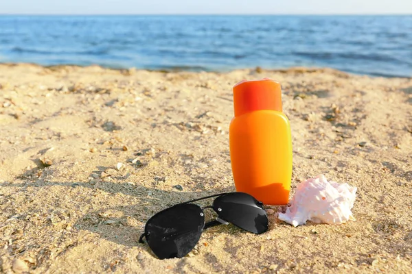 Sunglasses with shell and sunscreen cream — Stock Photo, Image