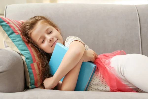 可爱的女孩与书在长沙发 — 图库照片