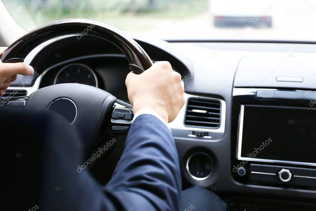 Male hands on steering wheel