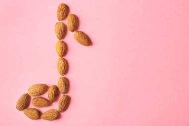 Badem pembe bir arka plan üzerinde yapılan Müzik Notası