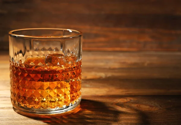 Glass of whisky on wooden table — Stock Photo, Image