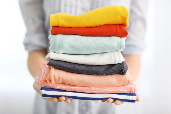 Woman holding stack of clothes