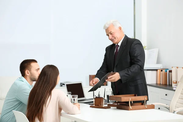 Unga par med notarien på kontor — Stockfoto