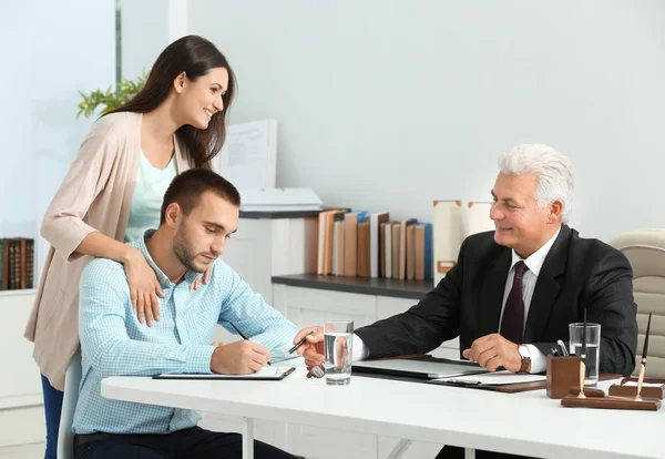 Pareja joven con notario en la oficina — Foto de Stock