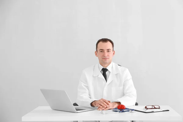 Médico Sentado Mesa Con Portátil Equipo Médico Sobre Fondo Claro — Foto de Stock