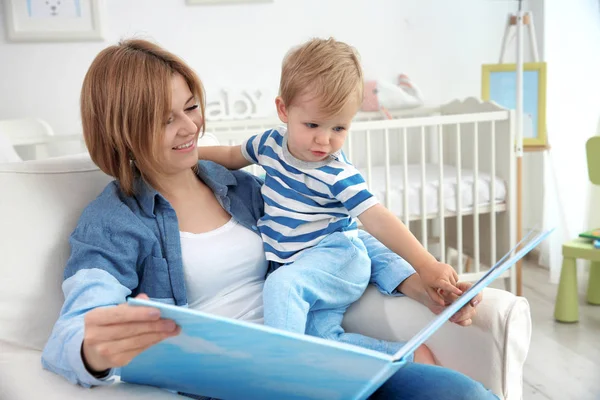 彼女の赤ちゃんの男の子の母読書 — ストック写真