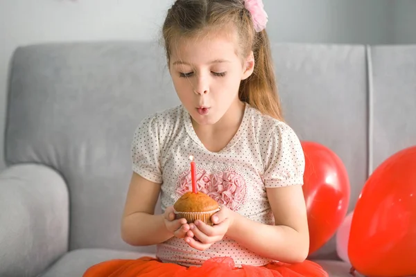 Cute little girl blowing out candle — Stock Photo, Image