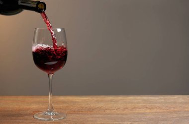 kırmızı şarap bardağa dökülüyor.