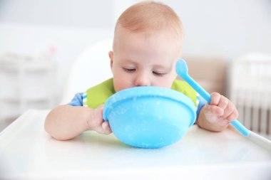 Küçük bebek kaseden kapalı kaşıkla yemek