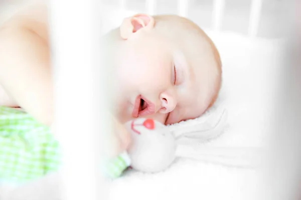 Kleines Baby schläft mit Spielzeugkaninchen — Stockfoto