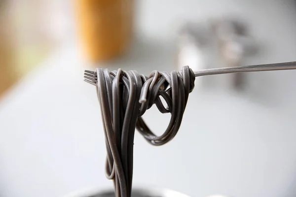 Black pasta on fork — Stock Photo, Image