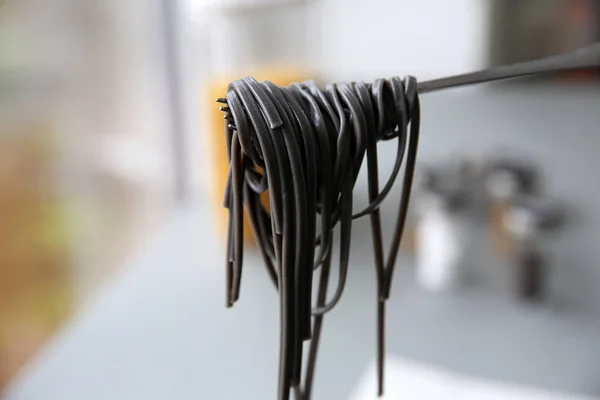Svart pasta på gaffeln — Stockfoto