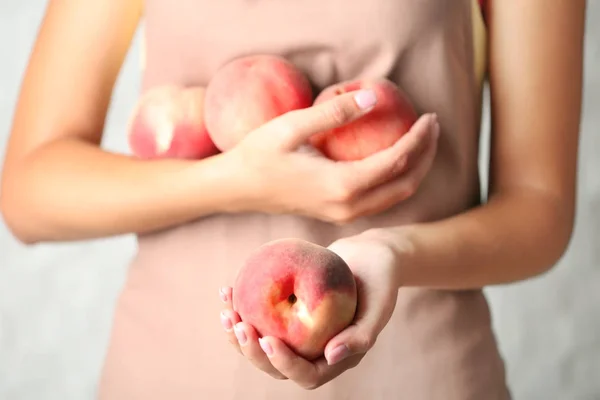 Woman holding peaches — Stock Photo, Image