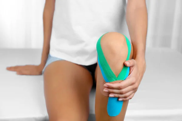 Vrouwelijke knie met physio tape — Stockfoto