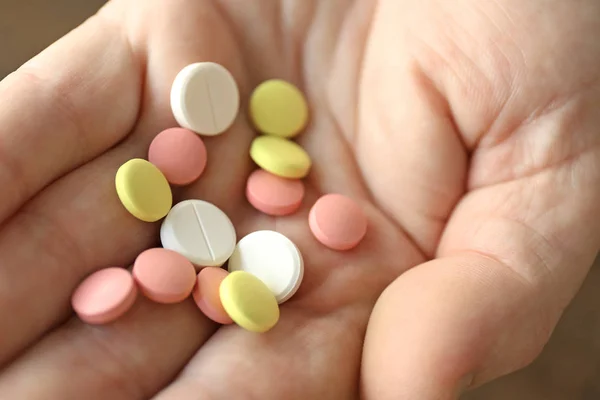 Pila de pastillas en mano masculina — Foto de Stock