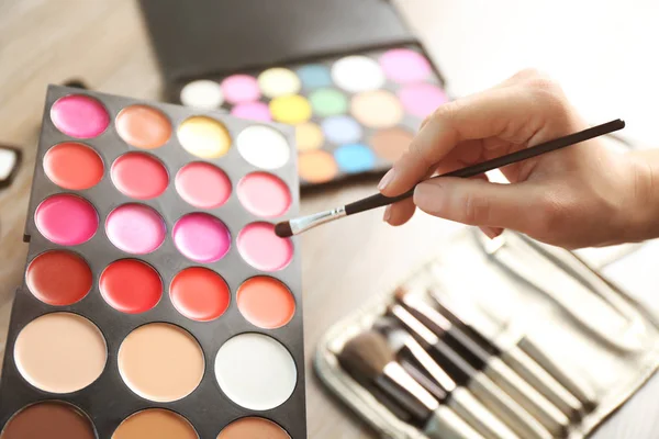 Mano femenina con paleta de lápiz labial — Foto de Stock