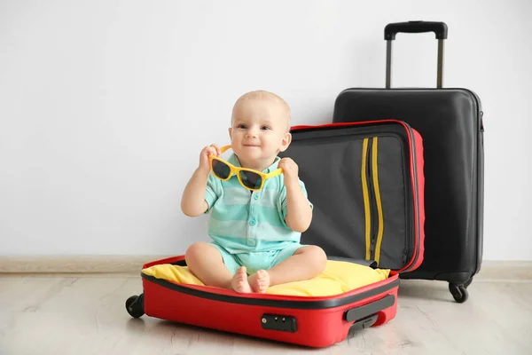 Bebé sentado en la maleta —  Fotos de Stock