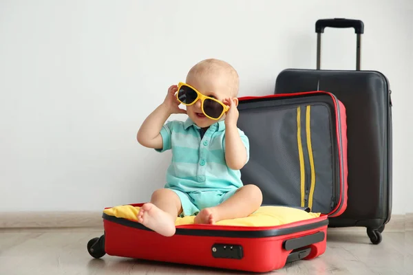 Bebê sentado na mala — Fotografia de Stock
